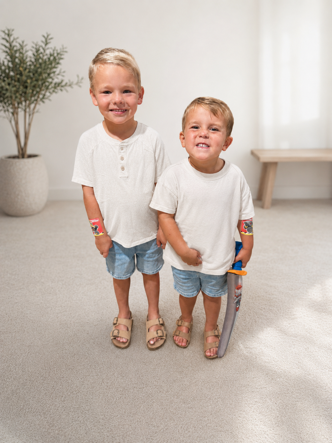 Two happy young children standing together at home